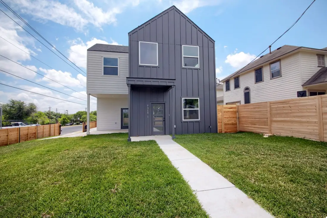 Charcoal board-and-batten home on Bennett Ave with a lawn
