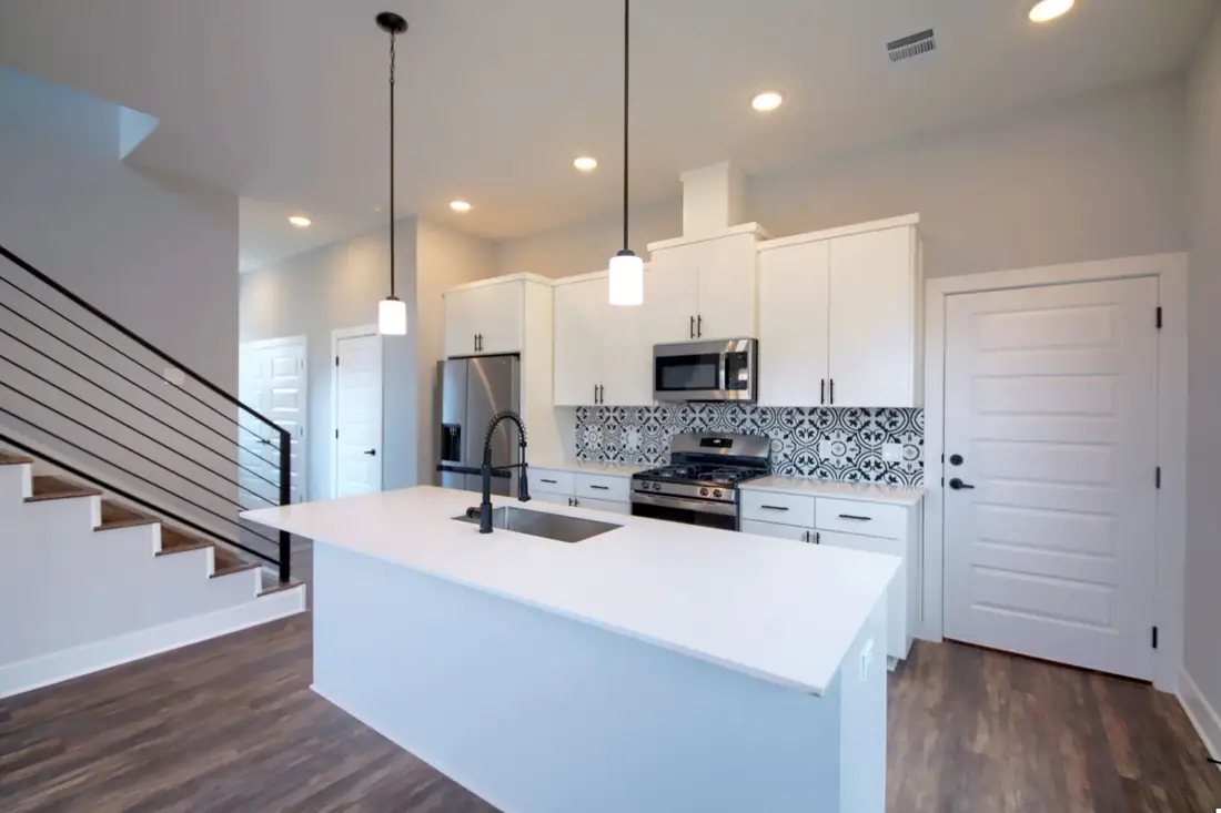 White kitchen island with a stair rail behind on Bennett Ave