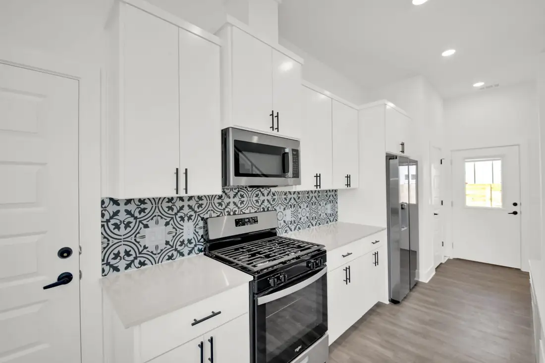 Kitchen with patterned tile backsplash and stainless range