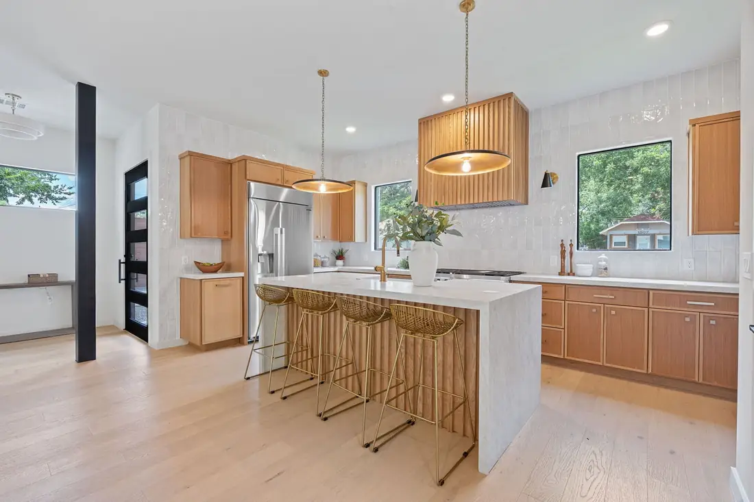 Oak kitchen with a waterfall island and brass pendants on Holly St