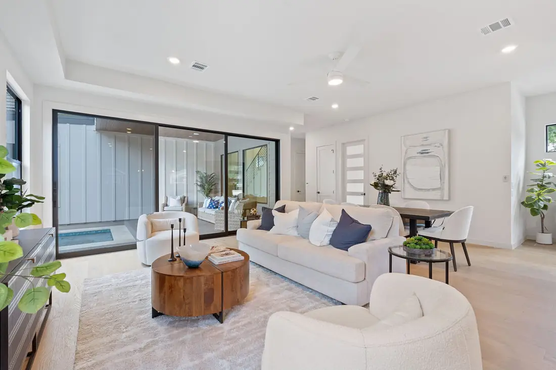 Open living and dining room with white oak floors and tall windows