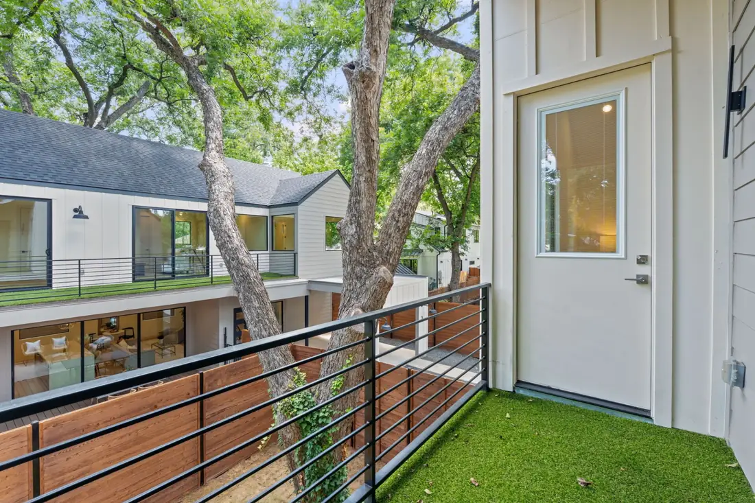 Upper balcony with turf and a mature tree canopy behind