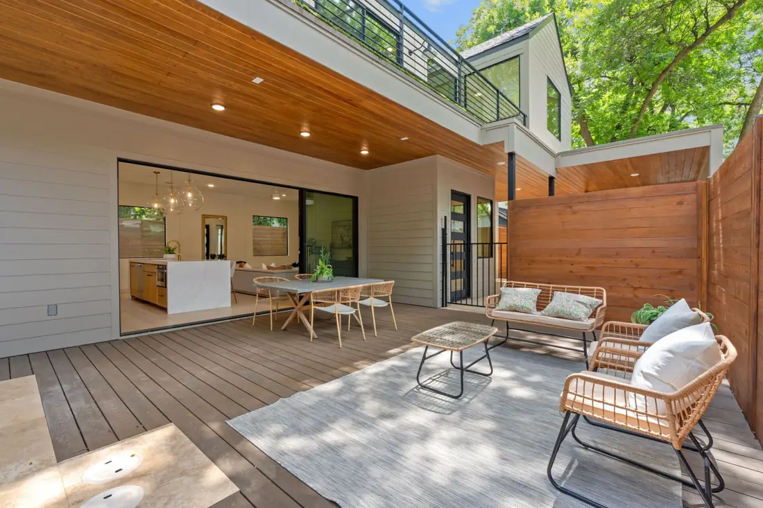 Wood-decked patio and pool beside a cedar privacy fence