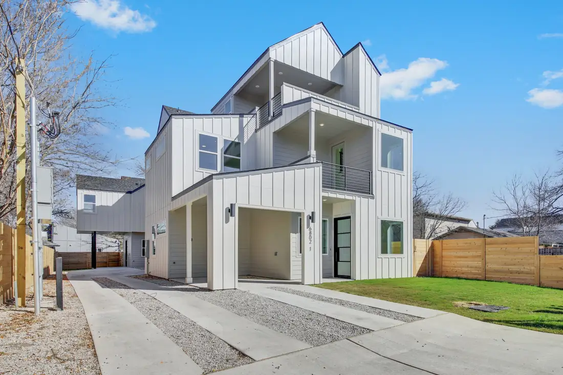 Three-storey white home on Montana St under a blue sky