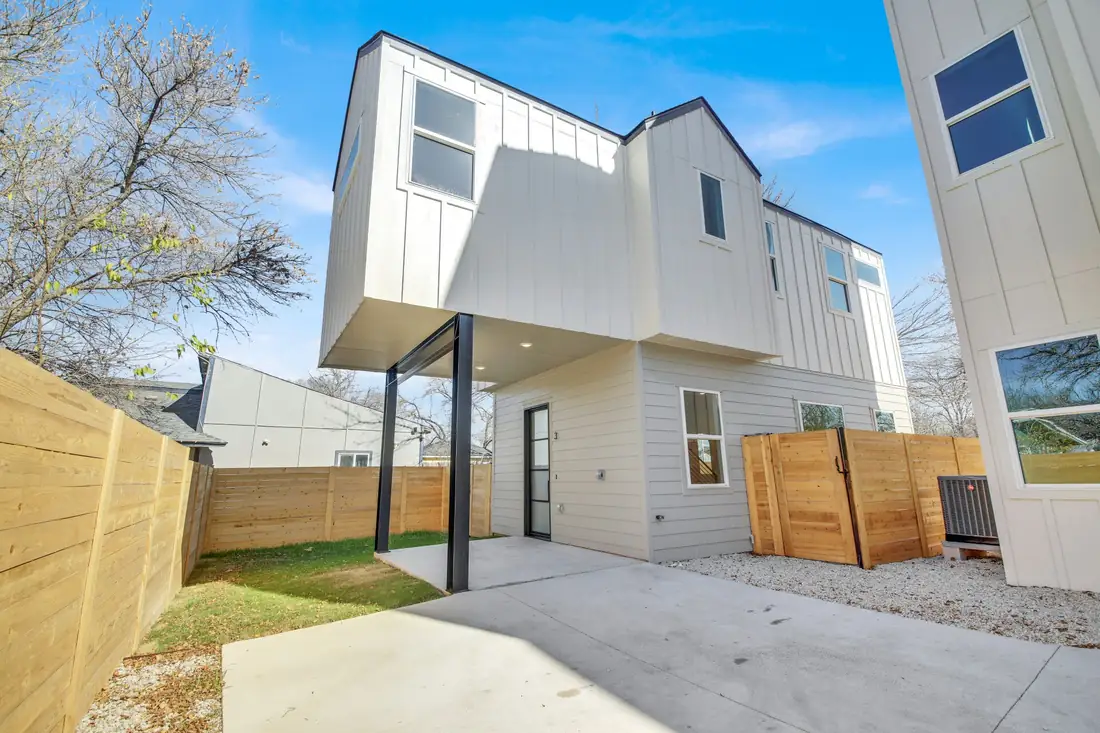 White home with a covered back porch and wood fence