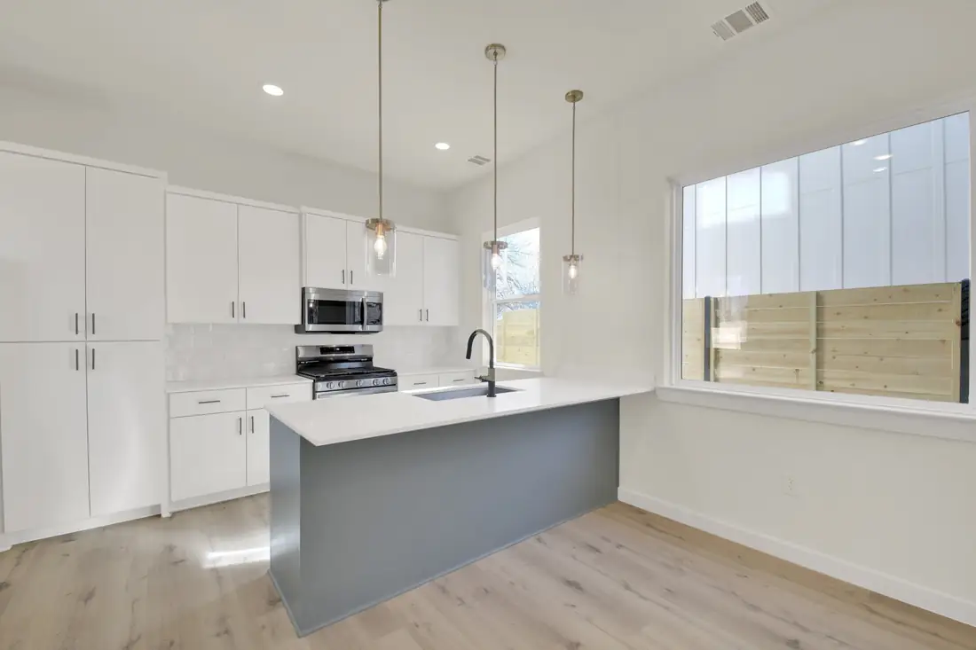 Bright kitchen with a grey island and pendant lights