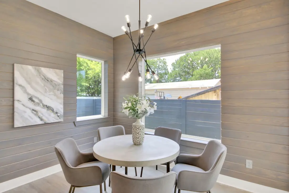 Dining nook with a wood accent wall and a sputnik chandelier