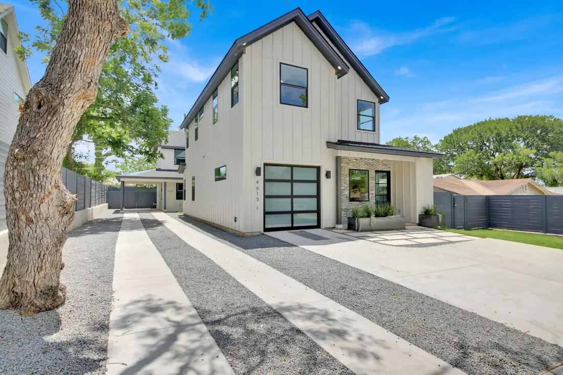 White board-and-batten farmhouse with a paver drive on S 2nd St